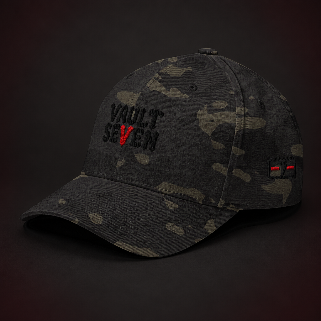 A dark camouflage baseball cap with 'VAULT SEVEN' embroidered on the front in black and red, set against a dark brown background.