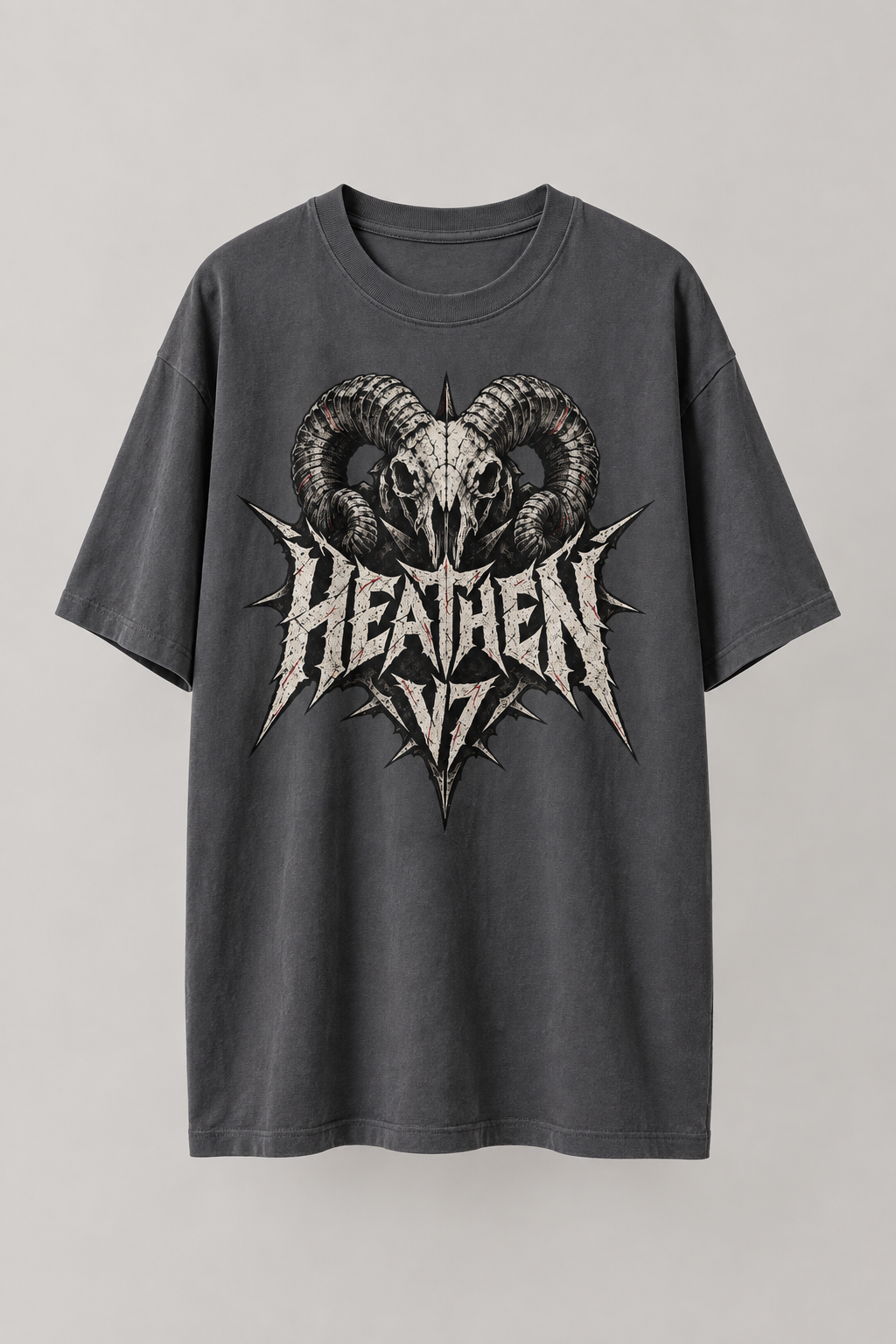 A dark gray short-sleeve t-shirt with a distressed graphic of a ram skull and the word 'HEATHEN V7' in a jagged metallic font, displayed against a neutral light gray background.