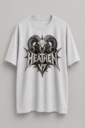 A light gray heather crewneck t-shirt featuring a large black and white graphic of a ram skull with the word 'HEATHEN' in a spiky metal font below it, displayed against a neutral gray background.