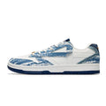 A low-top sneaker featuring a white leather base with blue distressed denim-like overlays, white laces, a white midsole with a dark blue outsole, and a small gold accent near the lace area.