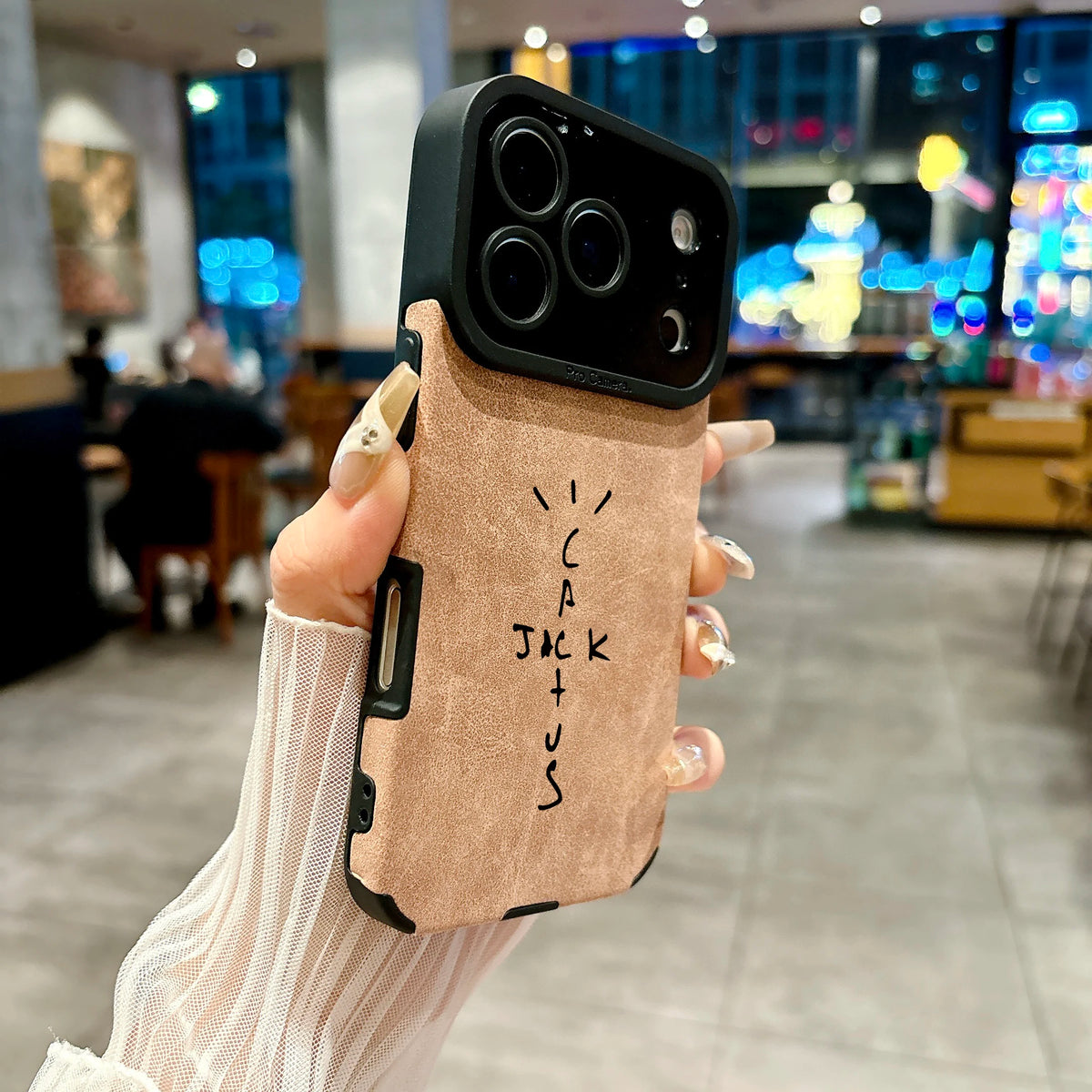 Hand holding a phone case with 'ICARUS' branding in an indoor setting.