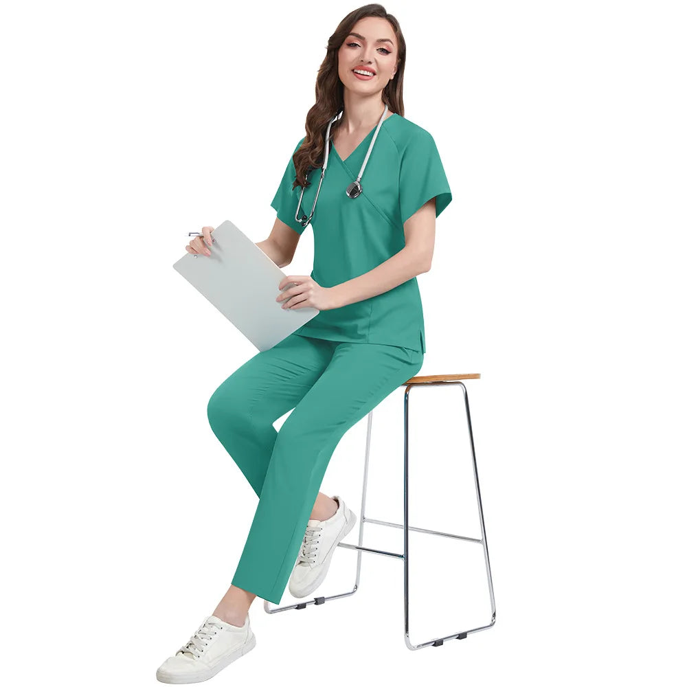 Person wearing teal medical scrubs sitting on a stool with a white background