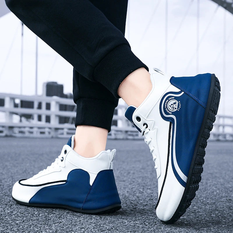 A person wearing blue and white low-top sneakers with black pants, standing on a paved surface with a blurred outdoor background.