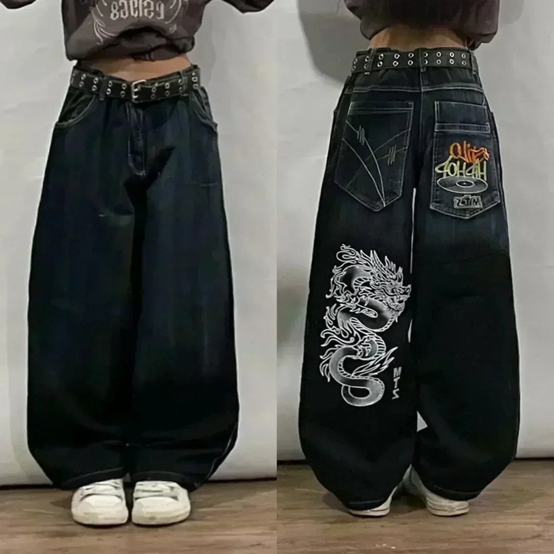 Black baggy jeans with dragon design and brand logo on a plain background
