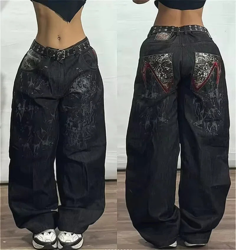 Black wide-leg pants with decorative patches worn by a person on a wooden floor.
