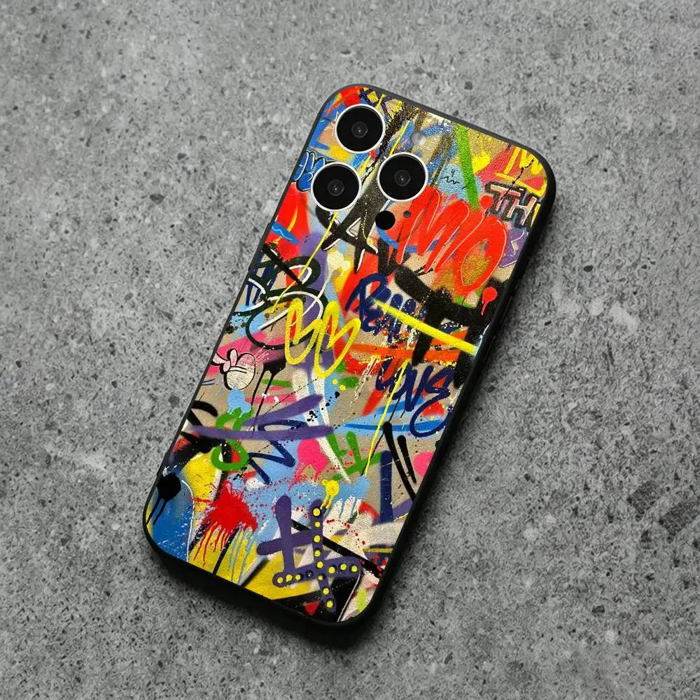A smartphone case with a vibrant graffiti art print, shown on a textured gray concrete surface. The design features a dense, multicolored spray-paint pattern with red, yellow, blue, green, and black elements.