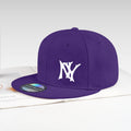 A purple flat-brim baseball cap with a white embroidered 'NY' logo on the front, resting on an open book against a light gray background.