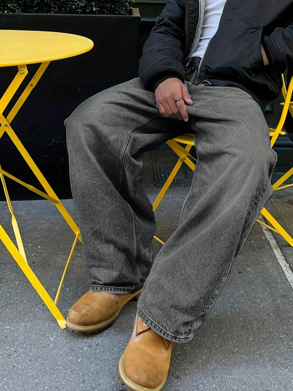 Person sitting on a yellow chair wearing gray jeans and brown boots.