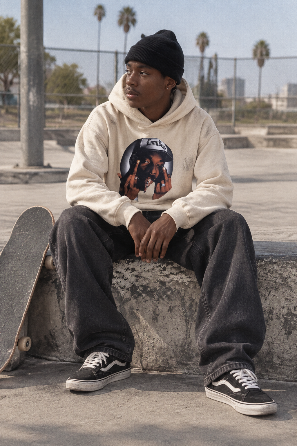 Person wearing the Snoop Dogg graphic hoodie in Color 3 at a concrete skate spot in natural daylight.