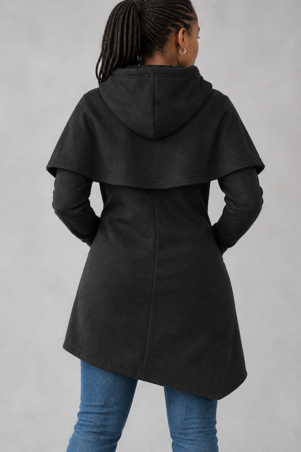 Black asymmetric hoodie back view showing hood and curved hem